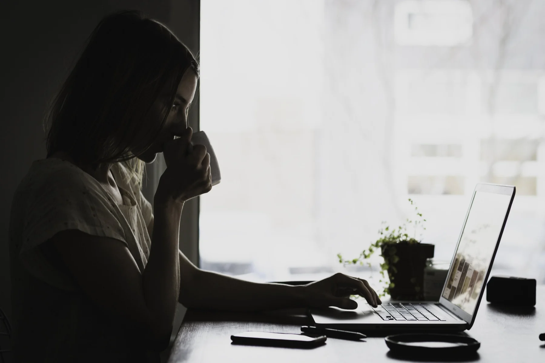 Professional working quietly at a laptop by a window